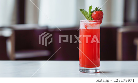 Strawberry juice served in a tall glass with mint garnish at a stylish cafe 125179971