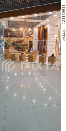 Shoe store window.A brightly lit glass shop window and a beautiful reflection on the tiled floor. 125180931