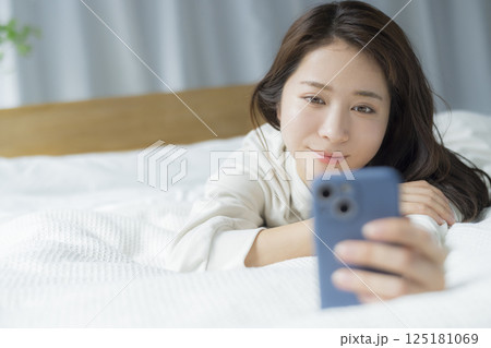 ベッドに寝そべる女性 125181069