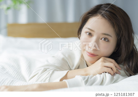 ベッドに寝そべる女性　  125181307