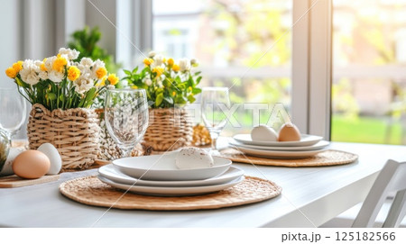 Light Easter table setting with white ceramic plates, natural rattan placemats, fresh tulip bouquets Light Easter table setting with white ceramic plates, natural rattan placemats, fresh tulip bouquets 125182566
