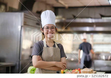 Portrait young teen girl cook student. Cooking class. Culinary classroom. Happy young woman students for cooking in cooking school. 125182672