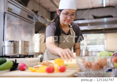 Focused chef preparing clean food ingredients from organic farm produce in a professional kitchen. Focused chef preparing clean food ingredients from organic farm produce in a professional kitchen. 125182747