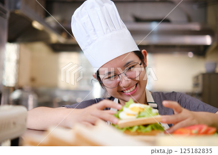 Focused chef carefully a gourmet sandwich in a professional kitchen with fresh ingredients in view Focused chef carefully a gourmet sandwich in a professional kitchen with fresh ingredients in view 125182835