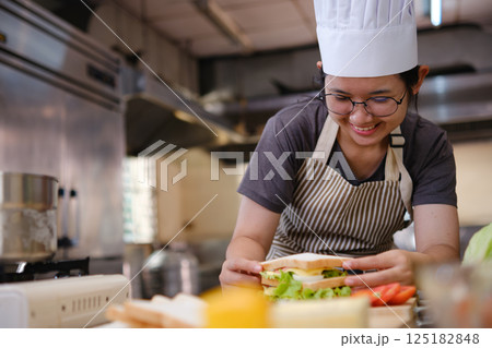Chef with a eggs sandwich ready for plating Chef with a eggs sandwich ready for plating 125182848