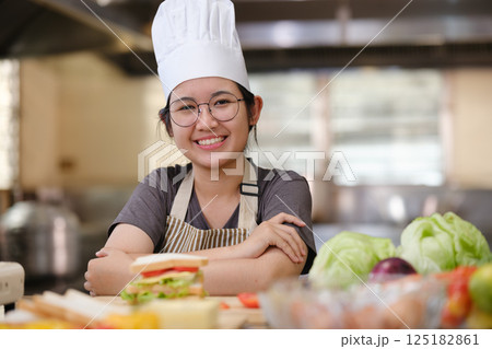 Culinary student standing confidently in training kitchen with fresh ingredients ready for cooking practice Culinary student standing confidently in training kitchen with fresh ingredients ready for cooking practice 125182861