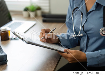 Documentation and Patient Care. A nurse records patient information during a medical consultation. Documentation and Patient Care. A nurse records patient information during a medical consultation. 125183010