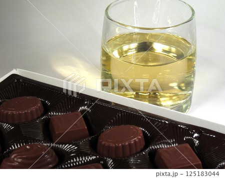 Glass of white wine and candies Glass of white wine and candies 125183044
