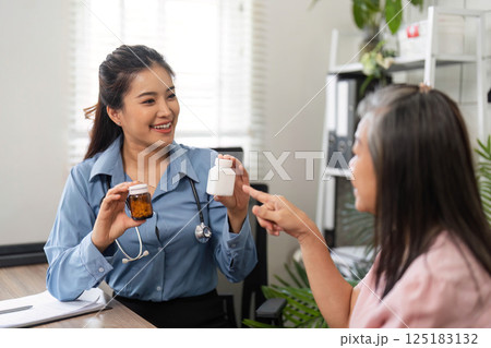 Healthcare and Empowerment. A nurse shares medication options with a senior patient in an engaging consult. 125183132