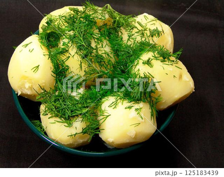 Boiled potatoes with greens decoration close view background Boiled potatoes with greens decoration close view background 125183439