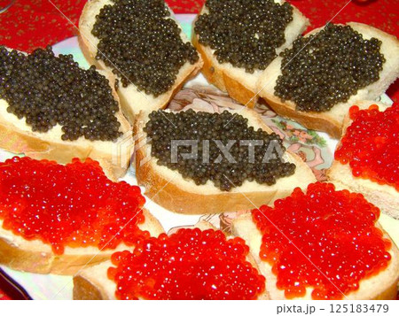 Red and black caviar over red background Red and black caviar over red background 125183479