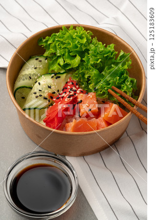 Fresh sushi bowl with salmon, avocado, and greens served with soy sauce 125183609