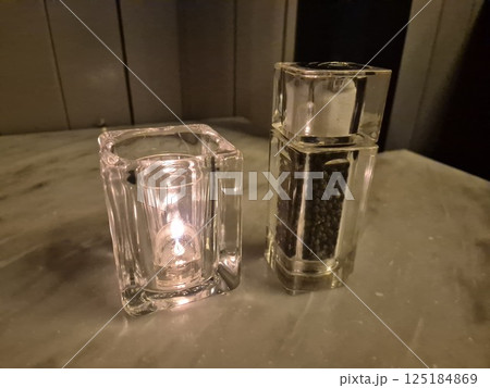Candle and pepper on a restaurant table background Candle and pepper on a restaurant table background 125184869