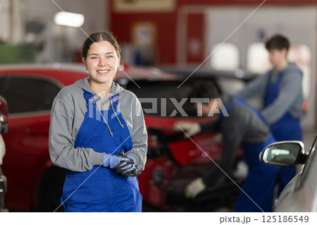 Service station young woman employee works in repair box, department Service station young woman employee works in repair box, department 125186549