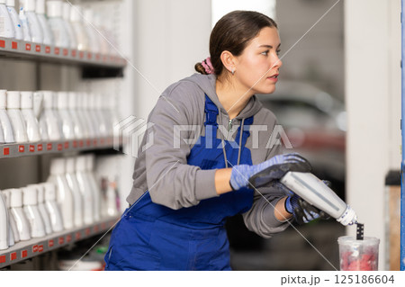 Girl auto colorist combines different paint colors Girl auto colorist combines different paint colors 125186604
