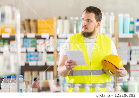 Young man builder chooses prescription medications 125186882