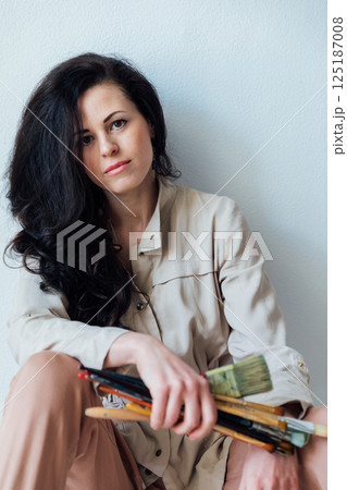 artist holding brushes in her hands to paint paintings artist holding brushes in her hands to paint paintings 125187008
