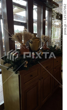 New Year's decor from dried flowers on a vintage chest of drawers, Christmas tree branches decorated the composition, clay vases look stylish New Year's decor from dried flowers on a vintage chest of drawers, Christmas tree branches decorated the composition, clay vases look stylish 125187062