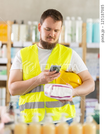 Checking expiration date of feminine pads - male builder scans QR code on label of feminine pads using smartphone Checking expiration date of feminine pads - male builder scans QR code on label of feminine pads using smartphone 125187085