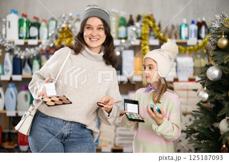 Mother and daughter shopping for cosmetics together during Christmas at home goods store Mother and daughter shopping for cosmetics together during Christmas at home goods store 125187093