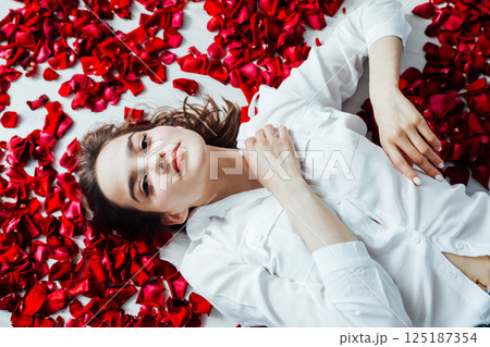 woman lying with red petals scent rose woman lying with red petals scent rose 125187354