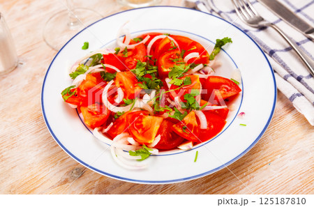 Vegetarian salad with tomatoes, onion, greens and olive oil Vegetarian salad with tomatoes, onion, greens and olive oil 125187810