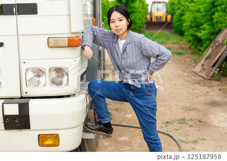 Chinese woman worker standing near truck at the orchard Chinese woman worker standing near truck at the orchard 125187958