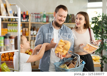 Couple of man and woman with boy choosing chicken in grocery 125188077