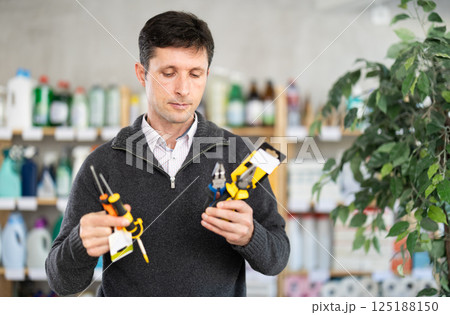 Adult man holding tools in his hands Adult man holding tools in his hands 125188150