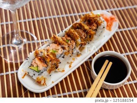 Rolls with salmon fish, avocado and fried onions 125188154