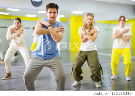 Emotional teen boy dancing with group of friends in dance studio. Hip hop generation Emotional teen boy dancing with group of friends in dance studio. Hip hop generation 125188336