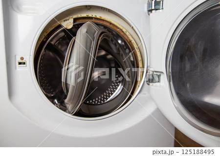 An old torn rubber seal for the sunroof with a defect, in the washing machine. Replacement of faulty spare parts, industry An old torn rubber seal for the sunroof with a defect, in the washing machine. Replacement of faulty spare parts, industry 125188495