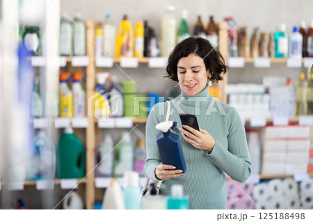 Adult woman scanning qr code for cleaning spray 125188498