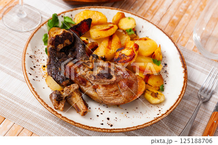 Roasted leg of lamb served with potatoes 125188706