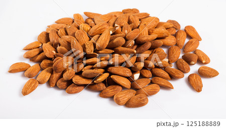 Close up of roasted almonds on white surface, no people 125188889