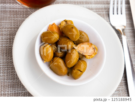 Pickled green olives with pits and garlic 125188945