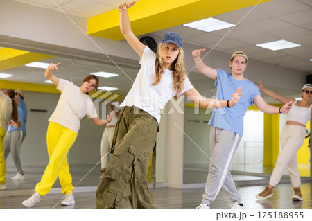 Group of young confident teenagers in casual clothes dancing together during exercise in class 125188955