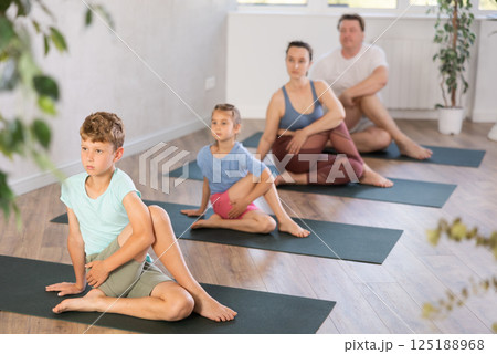 Family with two children doing yoga in studio Family with two children doing yoga in studio 125188968
