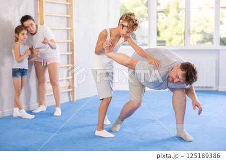 Father teaches his son to use forceful techniques and grips during self defense classes Father teaches his son to use forceful techniques and grips during self defense classes 125189386