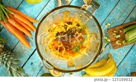 Fresh smoothie drink. Preparing smoothie in a blender. Mix of fruit and vegetable. 125189812