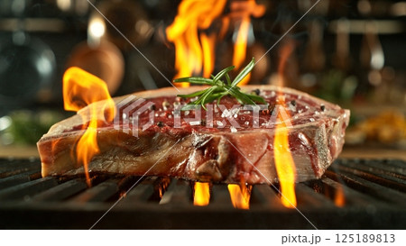 Beef Raw Steak on Grill with Fire. Preparation of Fresh Steak in Kitchen. Beef Raw Steak on Grill with Fire. Preparation of Fresh Steak in Kitchen. 125189813