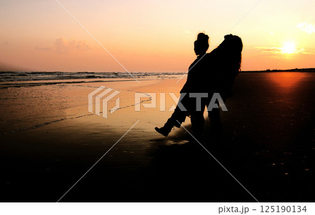 夕暮れの海辺に立つ女性二人 夕暮れの海辺に立つ女性二人 125190134