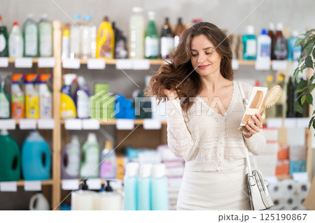 Young woman choosing hairbrush in store Young woman choosing hairbrush in store 125190867