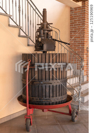 Traditional wooden wine press showcasing winemaking heritage in winery setting Traditional wooden wine press showcasing winemaking heritage in winery setting 125190969
