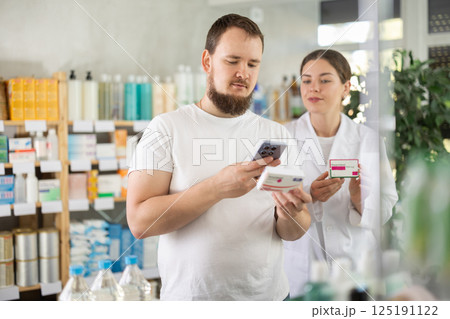 Man scans QR code on box paracetamol pills label. Female pharmacist offers to choose right shampoo 125191122