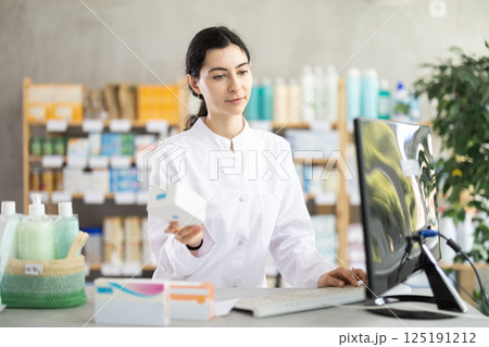 Female pharmacist searches for information about medicines on Internet Female pharmacist searches for information about medicines on Internet 125191212
