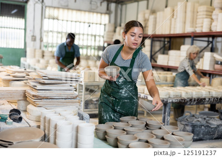 Female potter arrange pottery plate at factory ceramic Female potter arrange pottery plate at factory ceramic 125191237