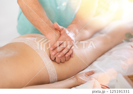 Woman lies and enjoys during anti-cellulite massage in buttocks Woman lies and enjoys during anti-cellulite massage in buttocks 125191331