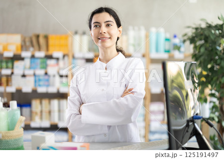woman pharmacist stands in a pharmacy 125191497