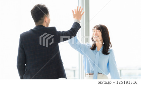 ハイタッチをする男女2人のビジネスマン 125191516